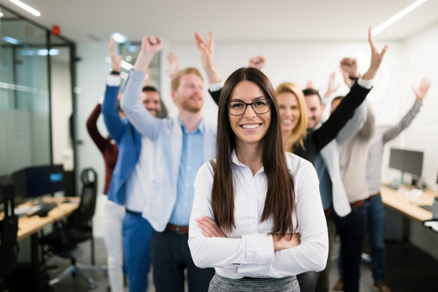 Mental Health. An image of a group of employees smiling at the camera and celebrating